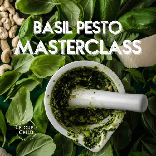Crushed pesto with basil leaves and pine nuts in the background